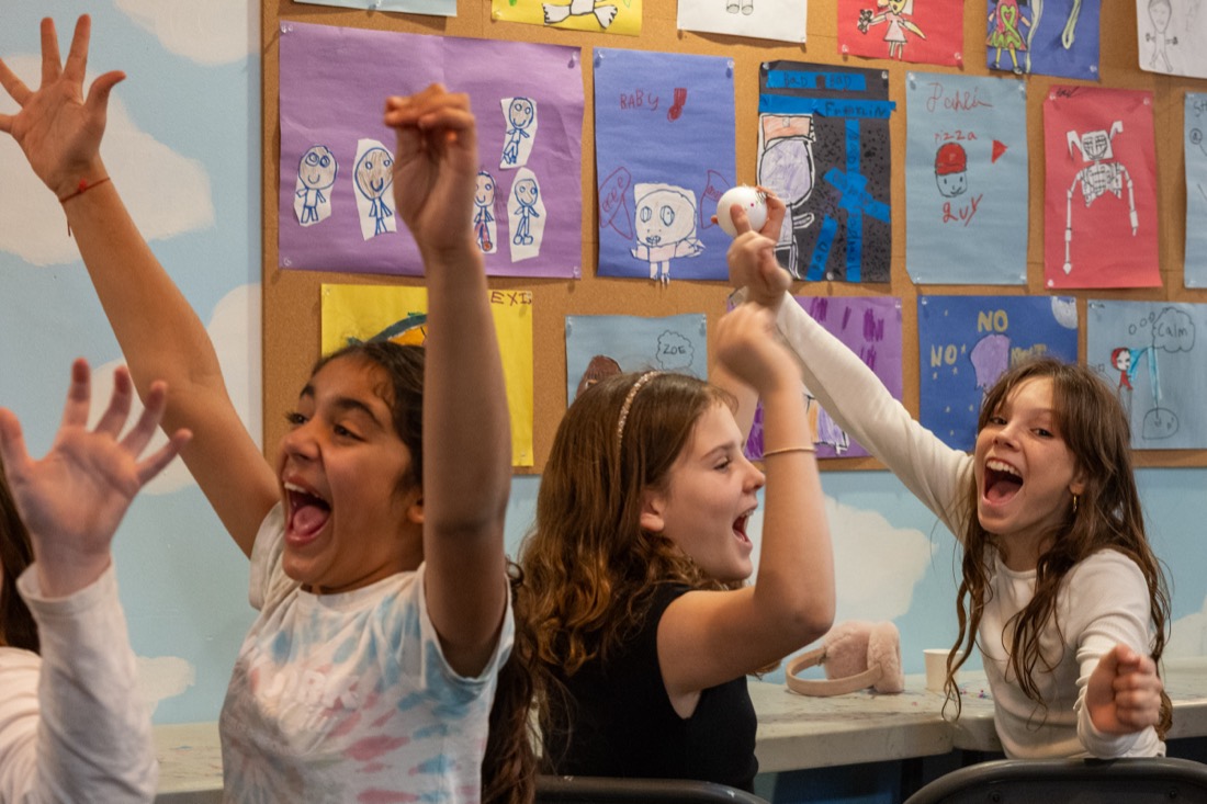 Students cheer with their arms in the air.